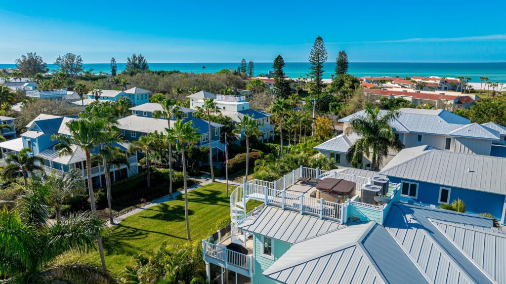 Aerial view of the neighborhood of Conrad Beach in Longboat Key showing the top of homes and the beach to the west.